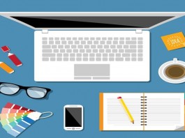 Notebook, óculos, celular e bloco de notas em coma da mesa