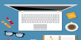Notebook, óculos, celular e bloco de notas em coma da mesa