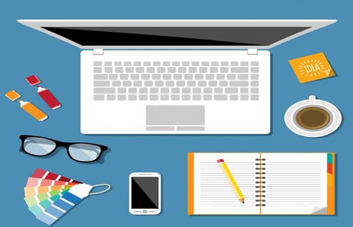 Notebook, óculos, celular e bloco de notas em coma da mesa